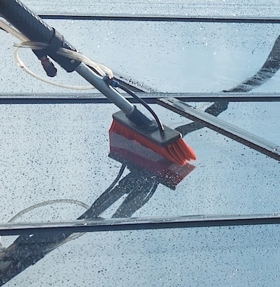 fensterreiniger-reinwasser-bürste-auf-glas-scheiben