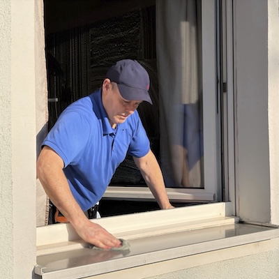 ein-fensterputzer-abwischt-alu-fensterbank-2026